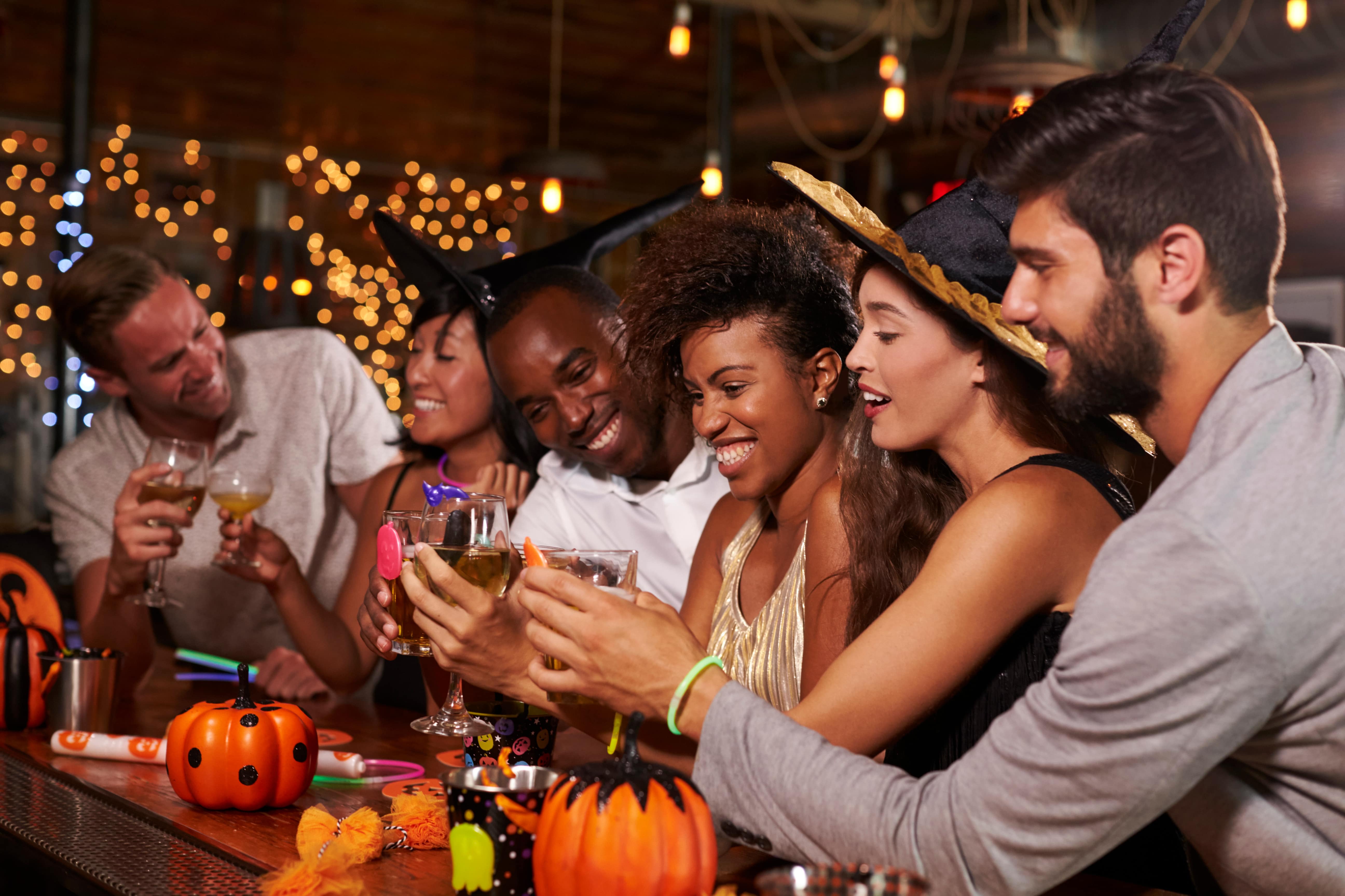 Friends enjoying a Halloween party at a bar making a toast