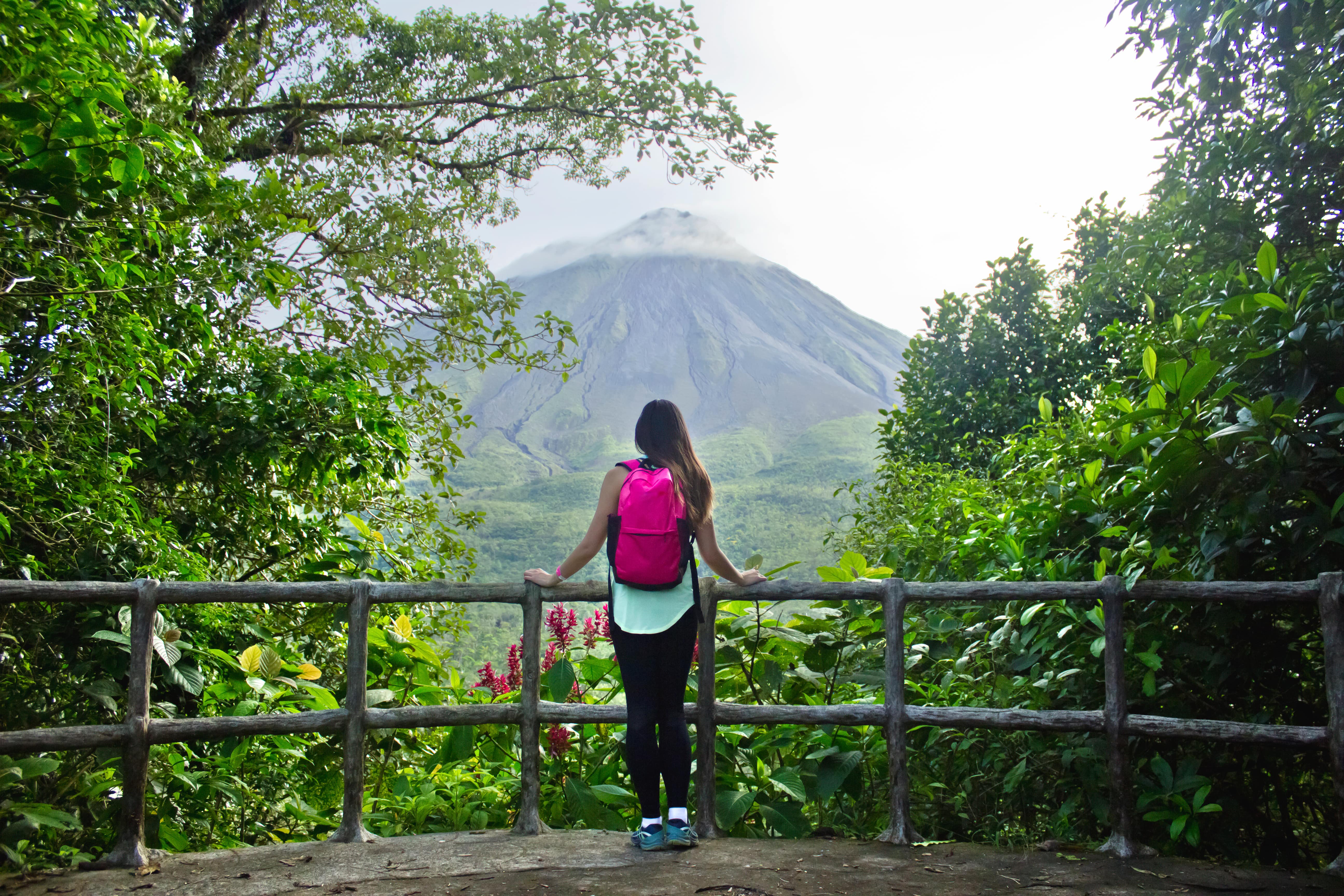 Female hiker looking out at the Arenal volcano in Costa Rica