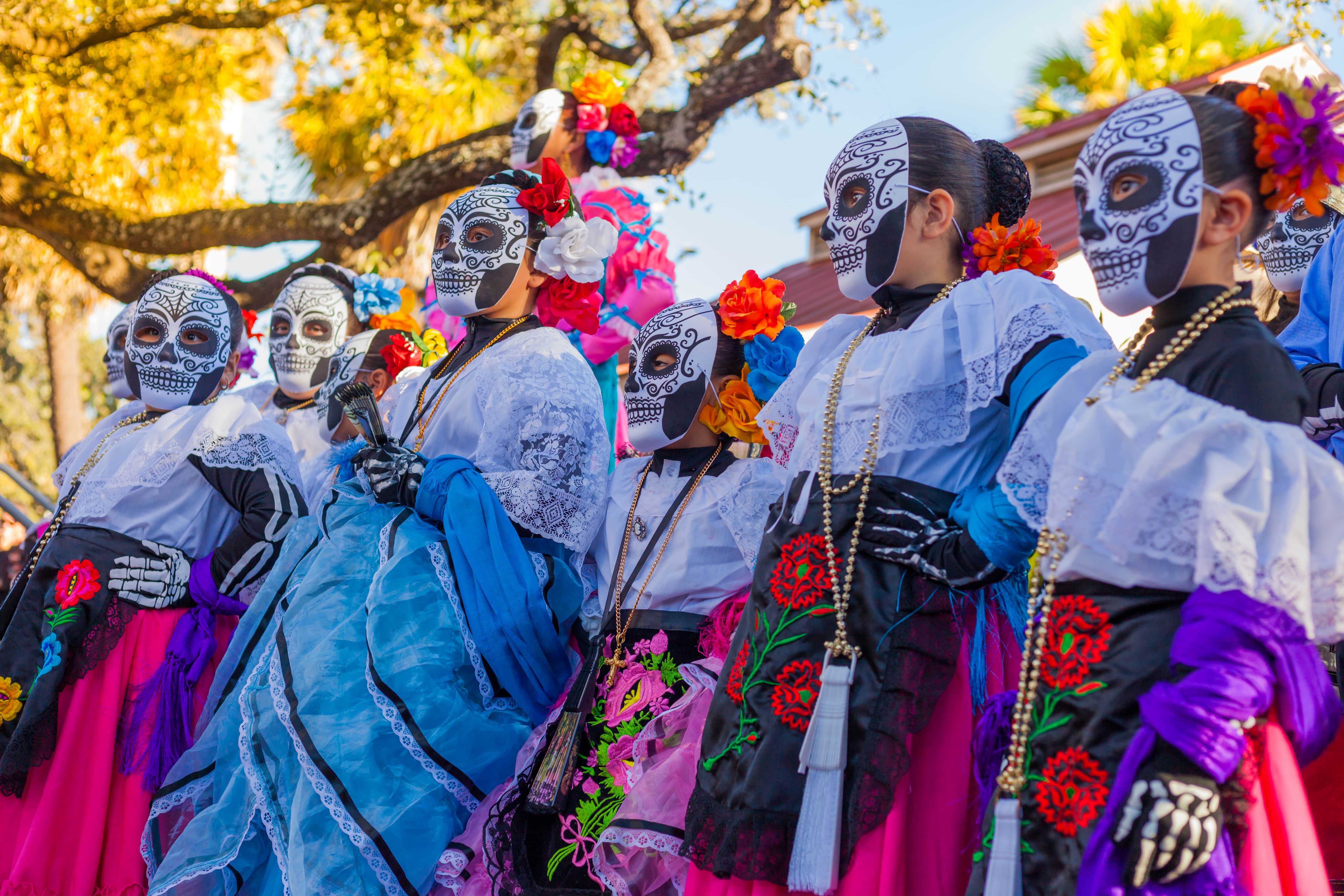 women wearing traditional sugar skull masks and costumes for Dia de los Muertos celebration in Mexico